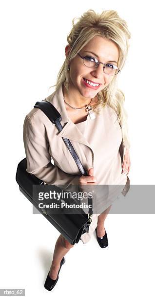 a caucasian blonde business woman holding a black bag smiles as she looks up at the camera - camera bag stock-fotos und bilder