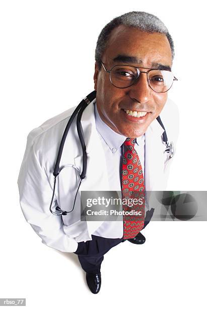 an african american male doctor wearing a tie and lab coat flashes a big smile as he looks up at the camera - smile stock-fotos und bilder