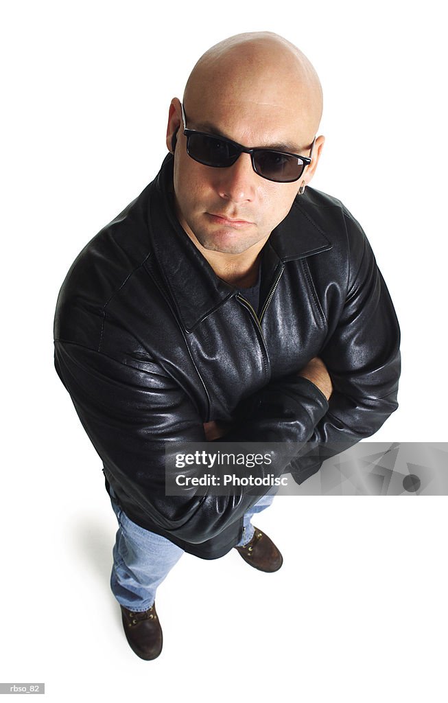 A caucasian male bodyguard in a leather jacket and sunglasses looks sternly up at the camera