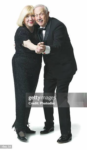 elderly couple smile as they dance together. - smile stockfoto's en -beelden