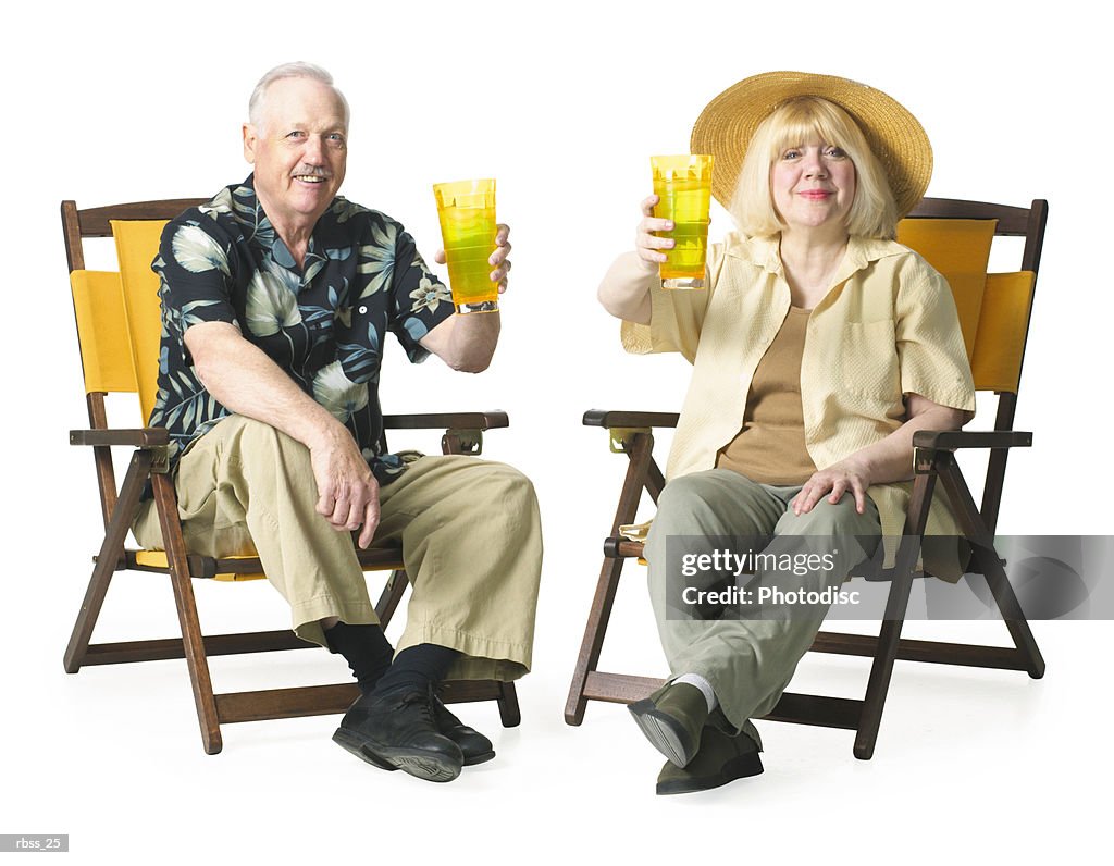 Elderly couple relax together sitting and enjoying a cold drink.