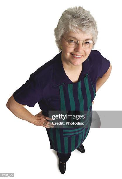 birdseye view of an elderly woman wearing an apron smiles up at the camera. - apron isolated stockfoto's en -beelden