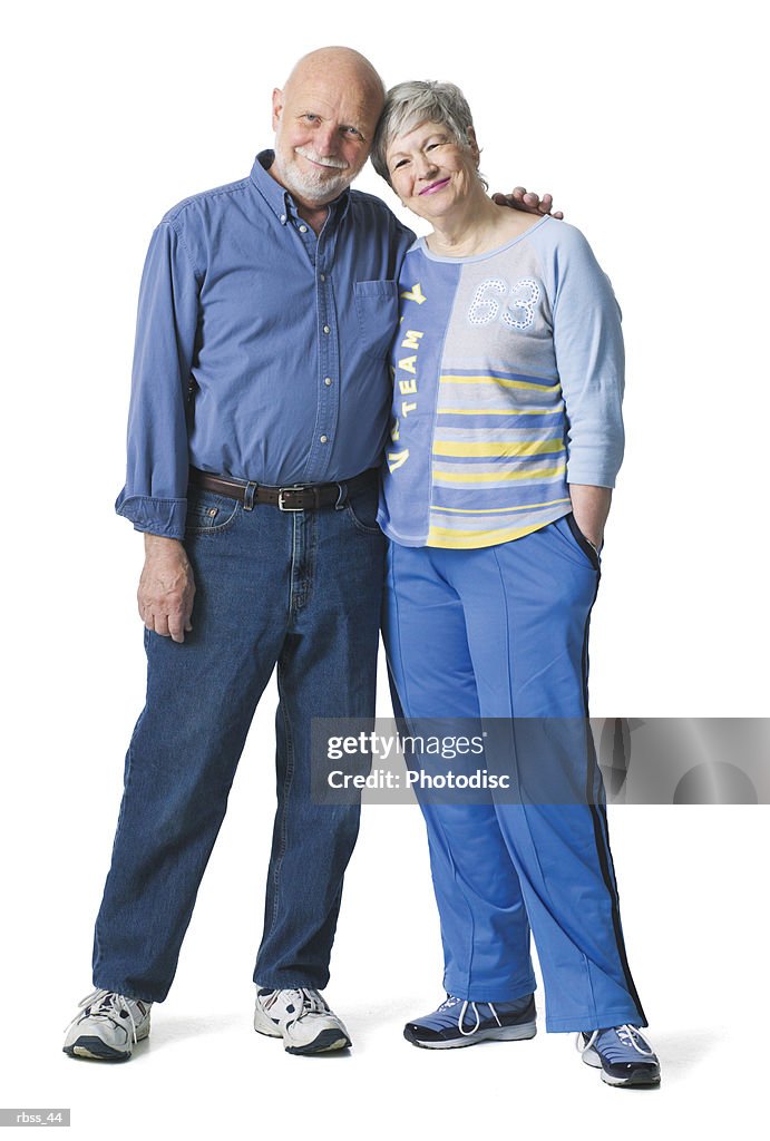 Elderly couple smile as they lean together.