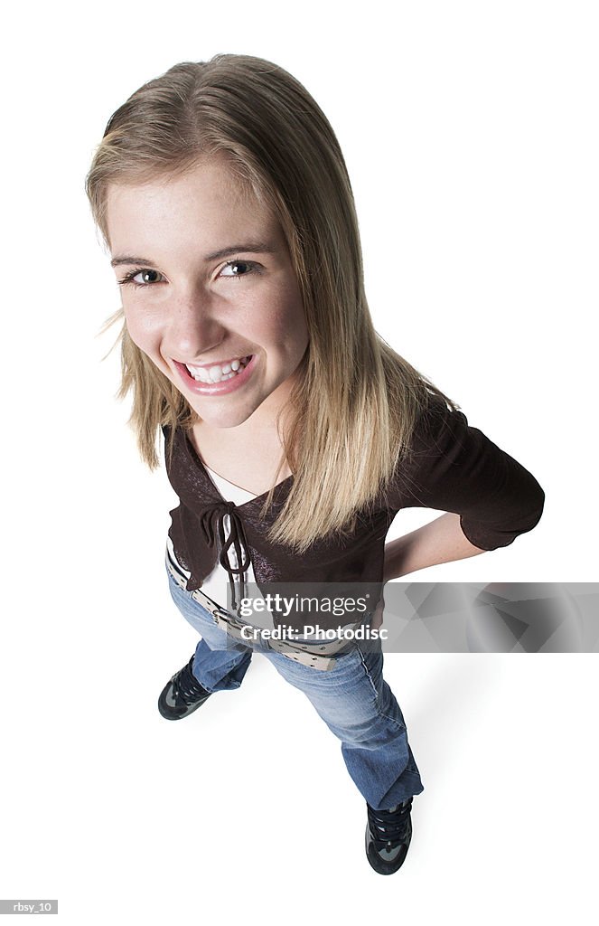 Portrait of a blonde caucasian female teen in jeans and a purple shirt as she smiles up into the camera