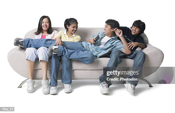 portrait of a group of asian brothers and sisters as they sit on the couch and fight over the remote control - control photos et images de collection