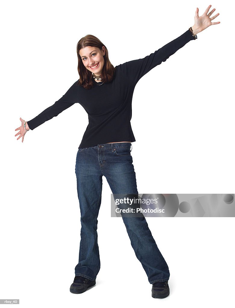 A caucasian female teen in jeans and a black shirt stretches out her arms and smiles