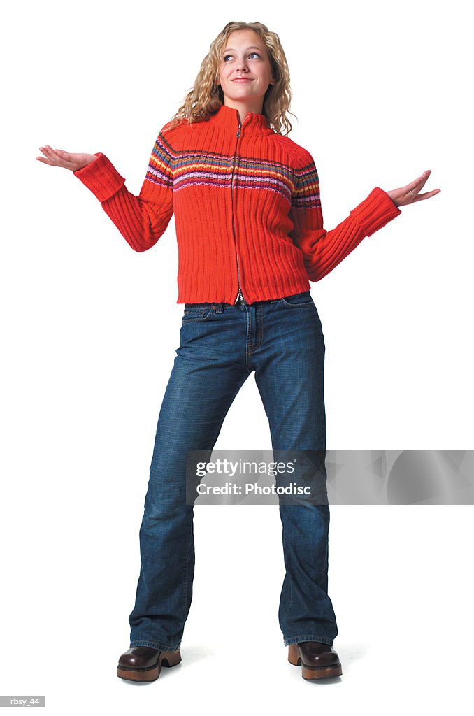 A caucasian blonde female teen in jeans and a red sweater tosses her arms out to the side