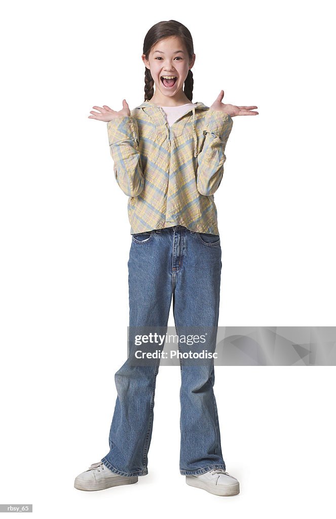 A young asian girl in jeans and a green shirt spreads out her hands and looks surprised