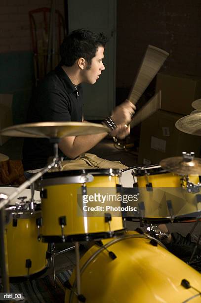 lifestyle portrait of a teenage male as he wildly plays the drums - rock moderne photos et images de collection