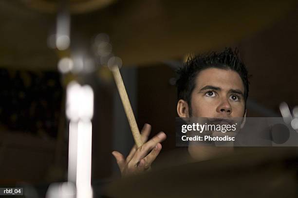 lifestyle portrait of a teenage male as he plays the drums and spins his drum sticks - modern rock bildbanksfoton och bilder