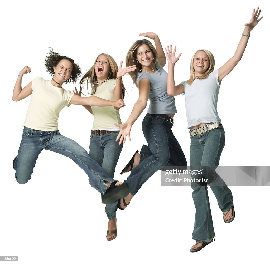 A group of four caucasian female teens jump up playfully into the air