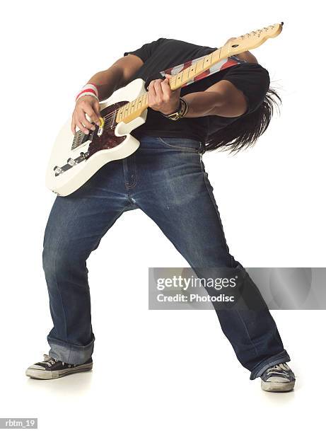 an asian male teen in jeans and a black shirt leans back while playing an electric guitar - modern rock bildbanksfoton och bilder