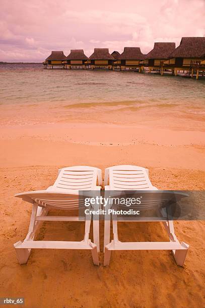 landscape photograph of two empty beach chairs overlooking a beautiful beach and resort - society islands stock pictures, royalty-free photos & images