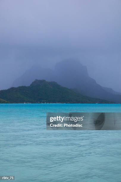 landscape photograph of crystal clear water and tropical mountains through the mist - crystal - fotografias e filmes do acervo