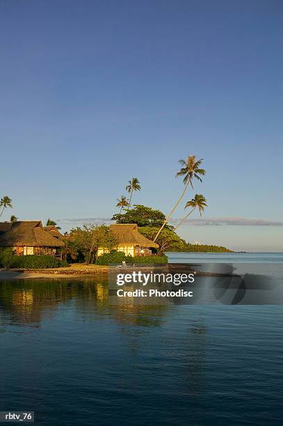 landscape photograph of a beautiful beach and grass huts of a tropical resort - gesellschaftsinseln stock-fotos und bilder