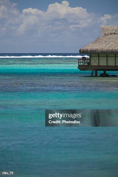 landscape photograph of a beautiful clear water and a grass hut - gesellschaftsinseln stock-fotos und bilder