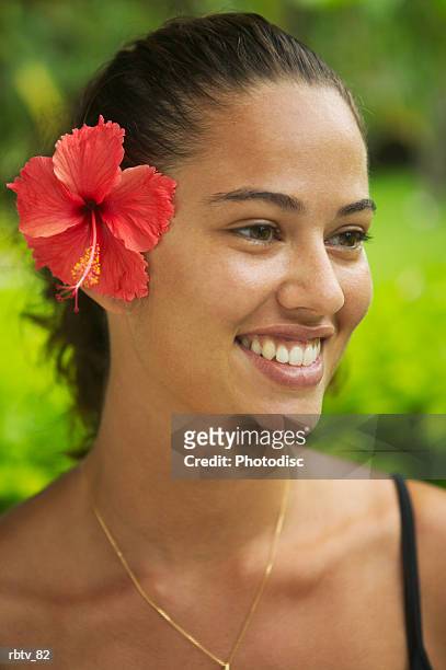 portrait of an attractive ethnic woman with a red flower in her hair as she smiles - society islands stock pictures, royalty-free photos & images