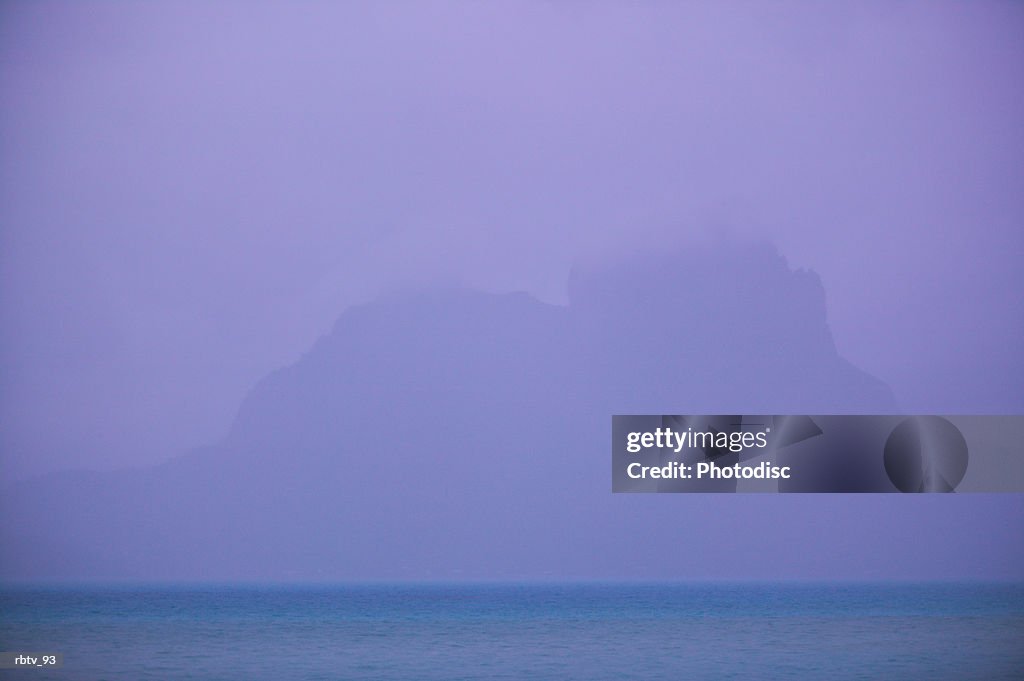 Landscape photograph of an island mountain seen through the ocean mist