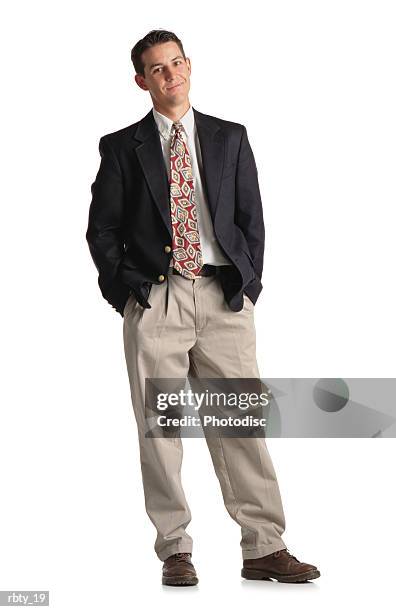 classy young buisness man in a suit with tie and khaki pants and navy blazer standing with weight shifted and a smirk on his face - khaki fotografías e imágenes de stock