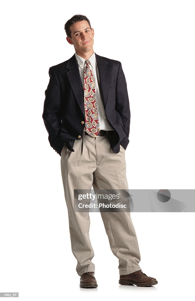 Classy young buisness man in a suit with tie and khaki pants and navy blazer standing with weight shifted and a smirk on his face