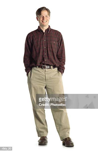 bright young caucasian male wearing a red plaid shirt and tan pants stands with shifted weight and smiles - tan tan stock pictures, royalty-free photos & images