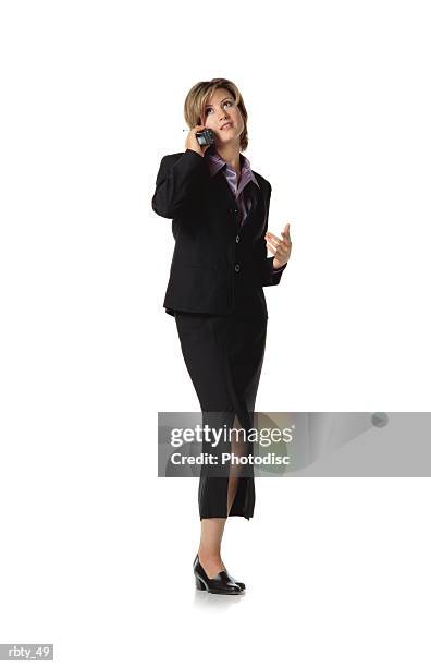 beautiful business woman with short brown hair wearing a purple silk shirt under a dark dress suit and skirt and black shoes talks into a cellular phone as she looks off into the distance - under the skirt - fotografias e filmes do acervo