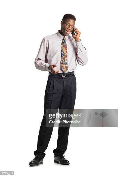 sharp looking young african american man in dress pants shirt and tie talks into a cellular phone and wears glasses - dress pants stock pictures, royalty-free photos & images