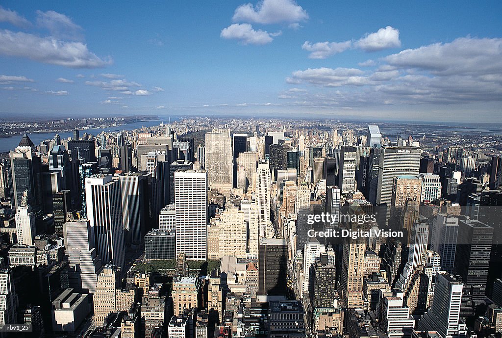 A shot of New York city from above with its skyscrapers and blue sky streaked with clouds
