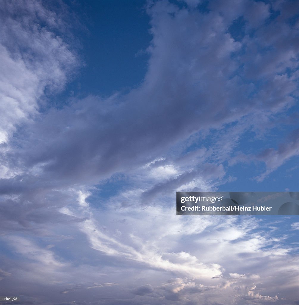 White clouds swirl in a blue sky