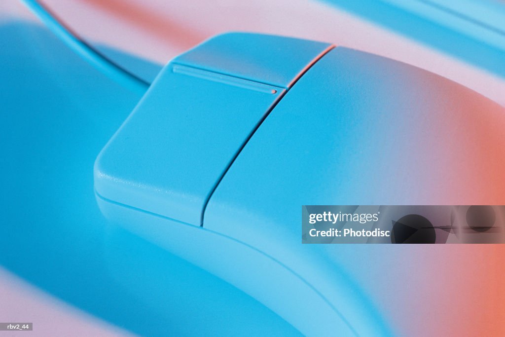 A computer mouse has blue and red light cast on it to crease blue shadows as it sits on a white background