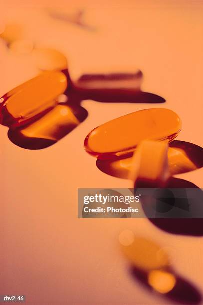 orange pills and gel caps rest on an orange background - rest cure stock-fotos und bilder