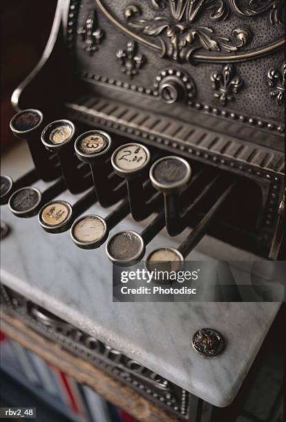 an antique cash register and its buttons sits on a black background - cash register stock-fotos und bilder