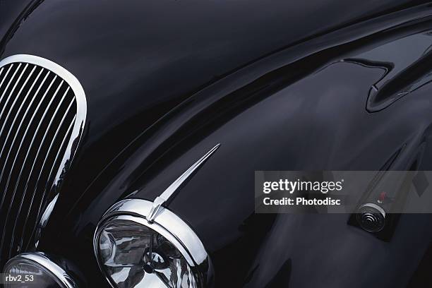 a black jaguar sports car hood showing a grill and headlight - luxury car stock-fotos und bilder