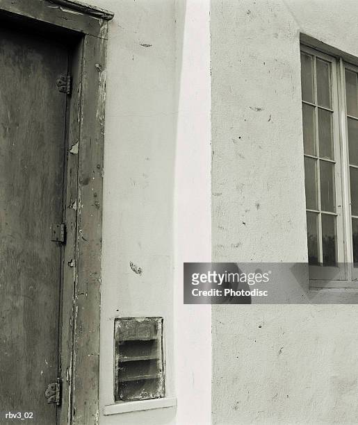 white stucco mexican mission style wall with window and gray door - door stockfoto's en -beelden