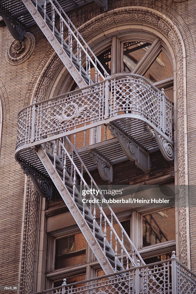 White steel ladders rise from glass windowed level to another of New York apartments