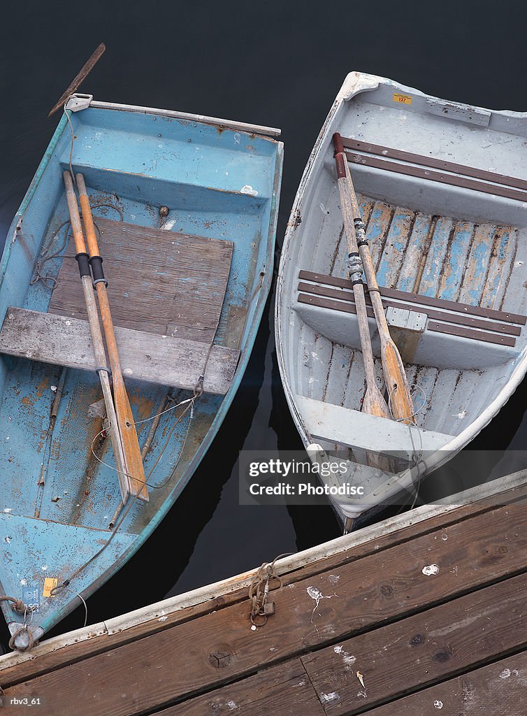 Two Blue Fishing Boats With Oars Float Next To Each Other At The Side Of A  Wooden Dock High-Res Stock Photo - Getty Images