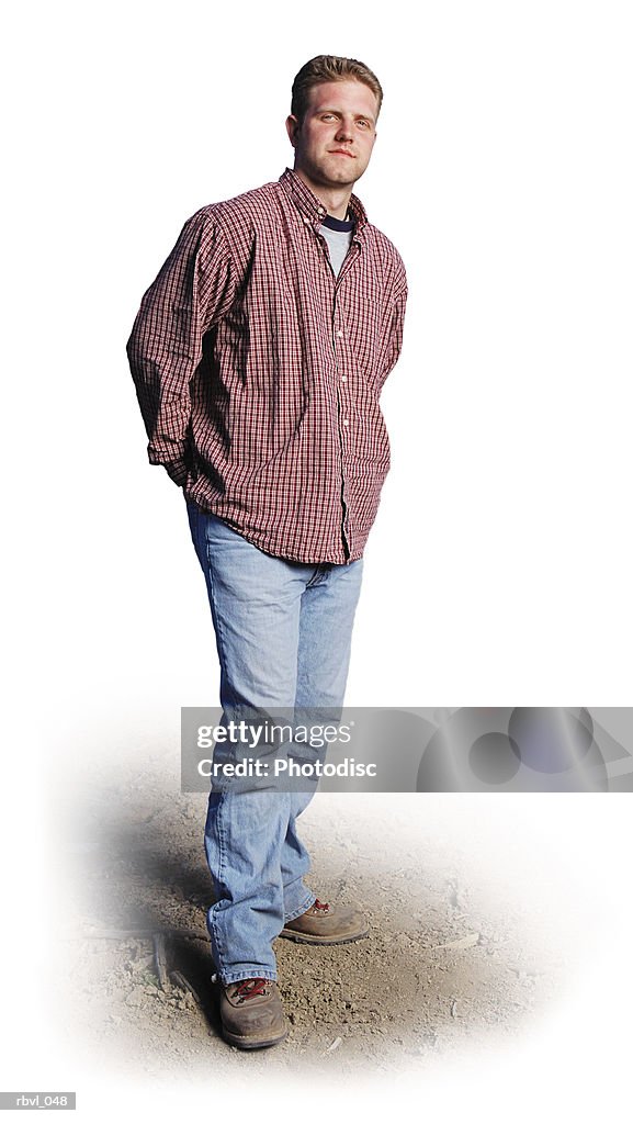 A young caucasian man with jeans and a red long sleeved shirt is standing outdoors looking into the camera