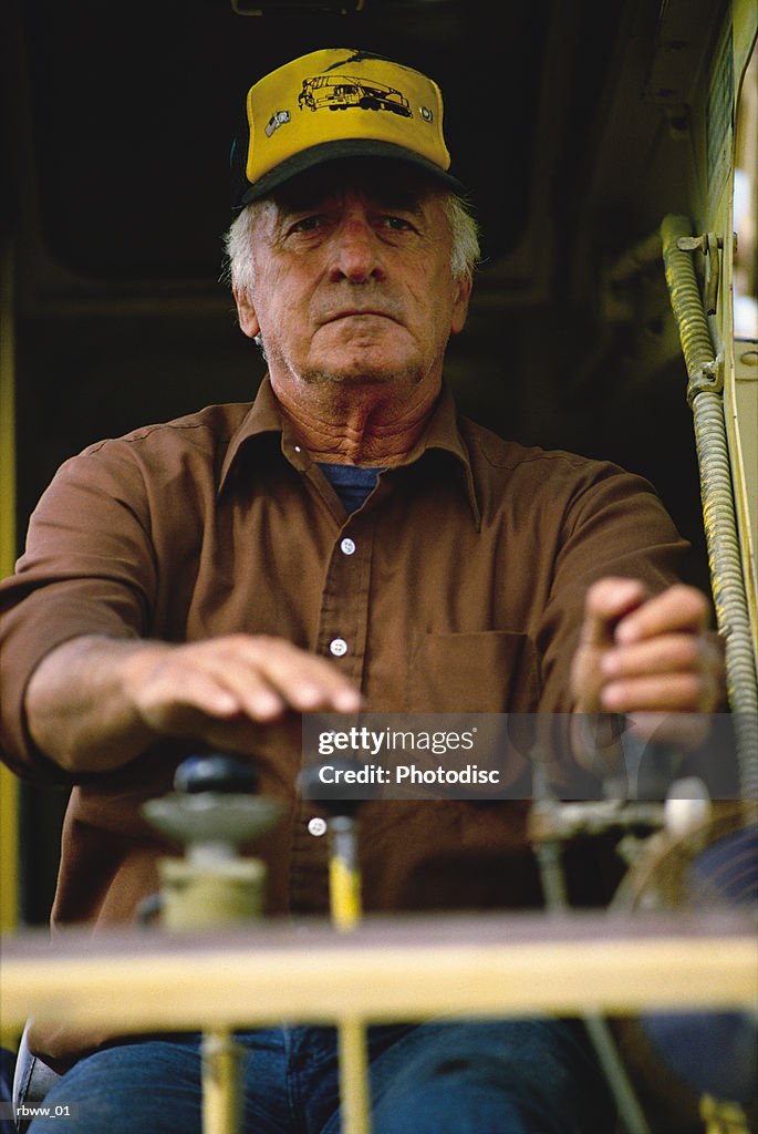 A caucasian older man operates construction machinery