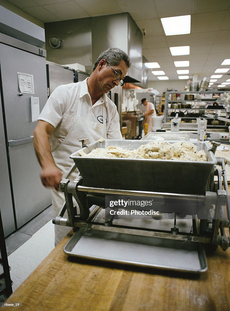 An older, male baker prepares some bread