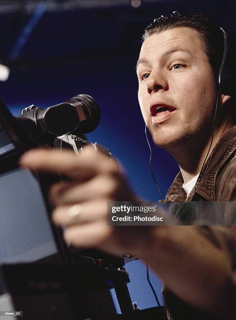 A caucasian man directs from behind the camera