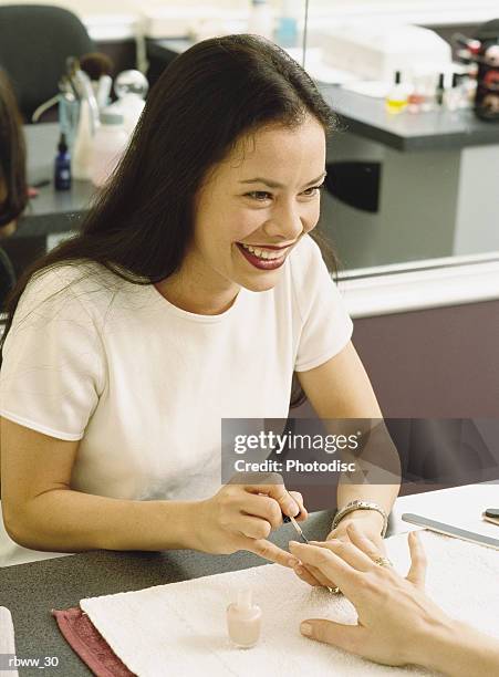 a beautician pauses to laugh with a customer as she works on her nails - lunghezza di capelli foto e immagini stock