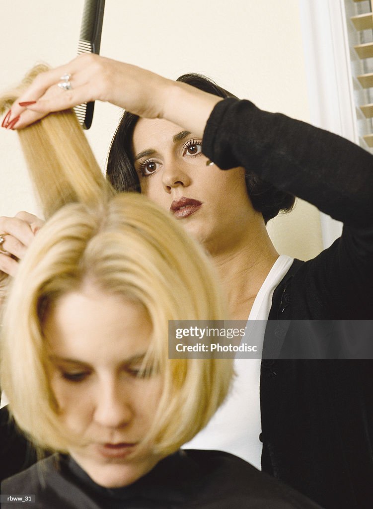 A caucasian woman gets her hair cut by a beautician