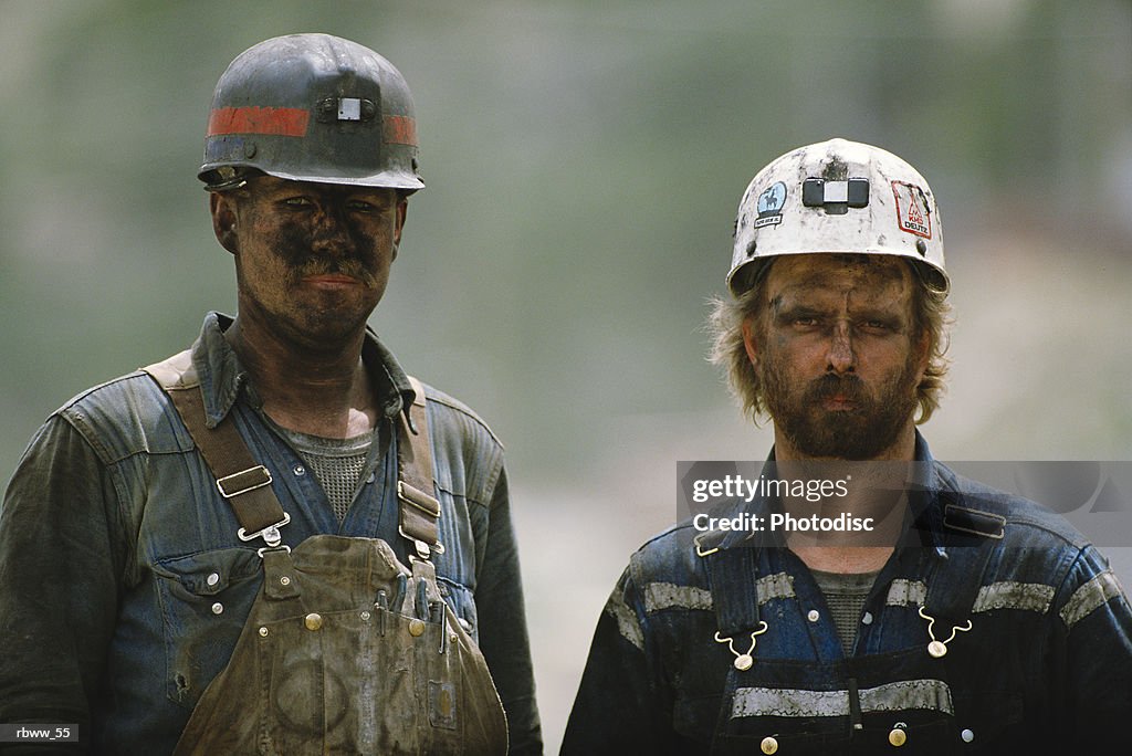Portrait of two soiled hard-working caucasian coal miners