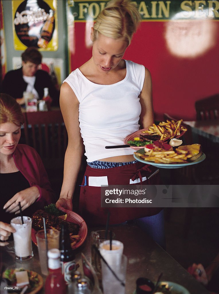 A blonde waitress delivers a meal to her customers