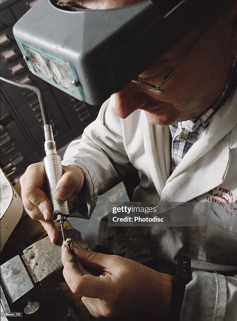 A jeweler repairs a diamond ring