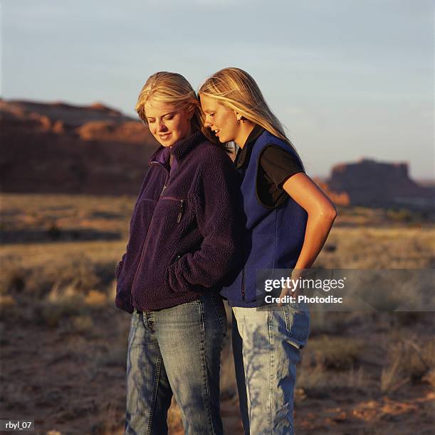 two young women with long blond hair standing together with the south utah desert in the background - long - fotografias e filmes do acervo