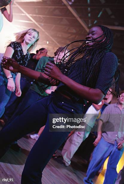 a young woman in a grey shirt and dark blue pants with long dark corn rows is dancing in a nightclub - long - fotografias e filmes do acervo