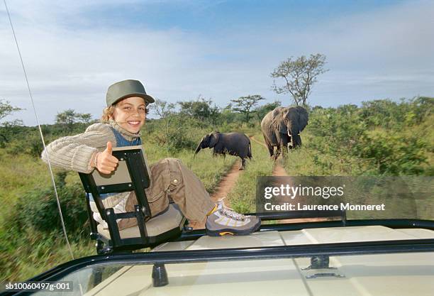 boy sitting on front seat showing thumbs up, smiling, portrait - safari stock-fotos und bilder