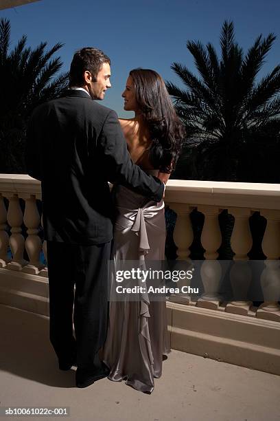 couple in evening wear on balcony, rear view - evening wear stock pictures, royalty-free photos & images