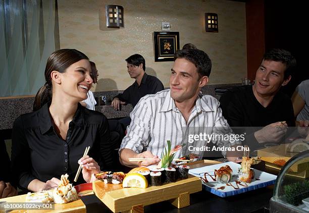 people in sushi bar, man and woman flirting - eating sushi stock-fotos und bilder